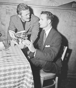 1956年4月，托马斯·杜利和演员科克·道格拉斯（Kirk Douglas）在一间餐馆里聊天，道格拉斯将在改编自杜利著作《引领我们脱离罪恶》的电影中扮演他本人。