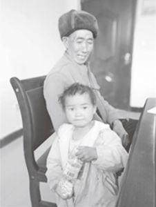 图1-10 贫困户杨光友老人与其丧父无母的孙女在村会议室