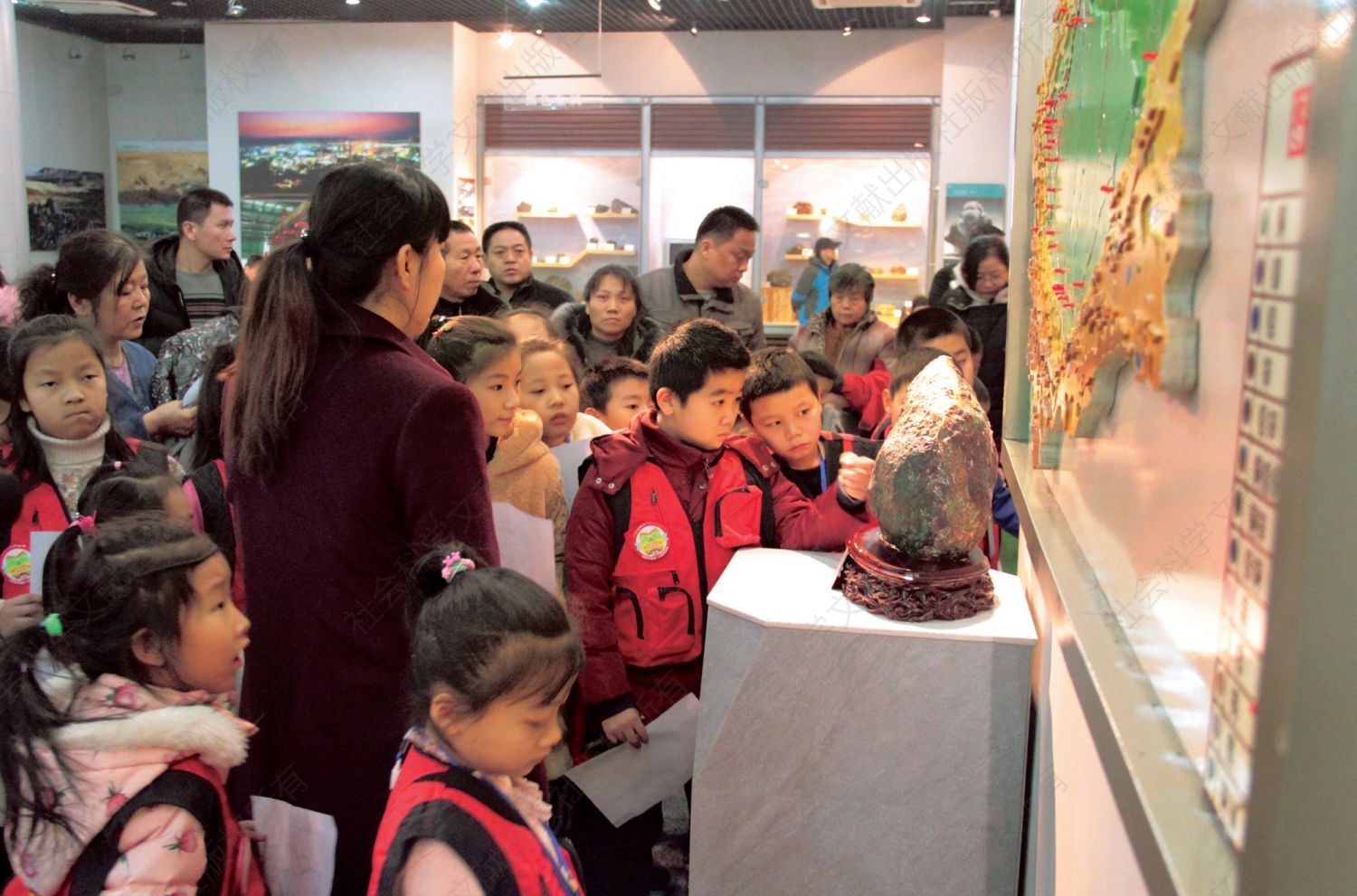1月11日，学生在“寻找彩虹宝石”寒假科普活动中带着答题卡参观展厅