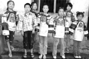 图3 “蒲公英行动”在湘西腊尔山阿拉小学，让那里的苗族孩子在美术课上穿上了自己用废报纸设计制作的苗族服饰（图片由“蒲公英行动”项目提供）
