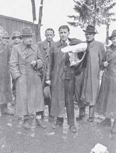 火箭专家韦恩赫尔·冯·布劳恩（打着石膏绷带）和佩内明德陆军试验所所长沃尔特·多恩贝格尔（前排左侧）于1945年5月2日投靠美国人。（akg-images，Berlin）