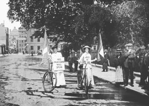 1914年，推着自行车的妇女参政权论者，为妇女社会政治同盟与埃米琳·潘克赫斯特（Emmeline Pankhurst）的会面进行宣传。