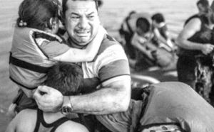 图4-9 一位逃离叙利亚战争的父亲抵达希腊科斯岛后，抱着孩子喜极而泣