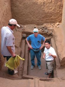 考古队员及来访学者在刚刚清理出来的商代墓室内（2004年，侯玉林、James Stoltman、岳占伟）