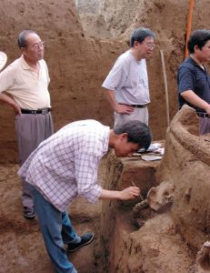 考古队员在商代马车清理现场（2005年，左至右：杨锡璋、徐广德、何毓灵）