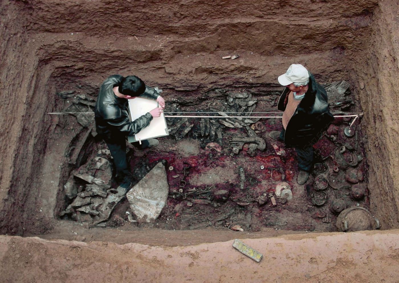 考古队员在清理商代墓葬（左：屈光富；右：张贵生）