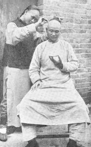 晚清西方传教士所摄成都街边剃头匠。这些流动剃头匠可以在街边提供服务。戴维森和梅益盛摄，1905年。