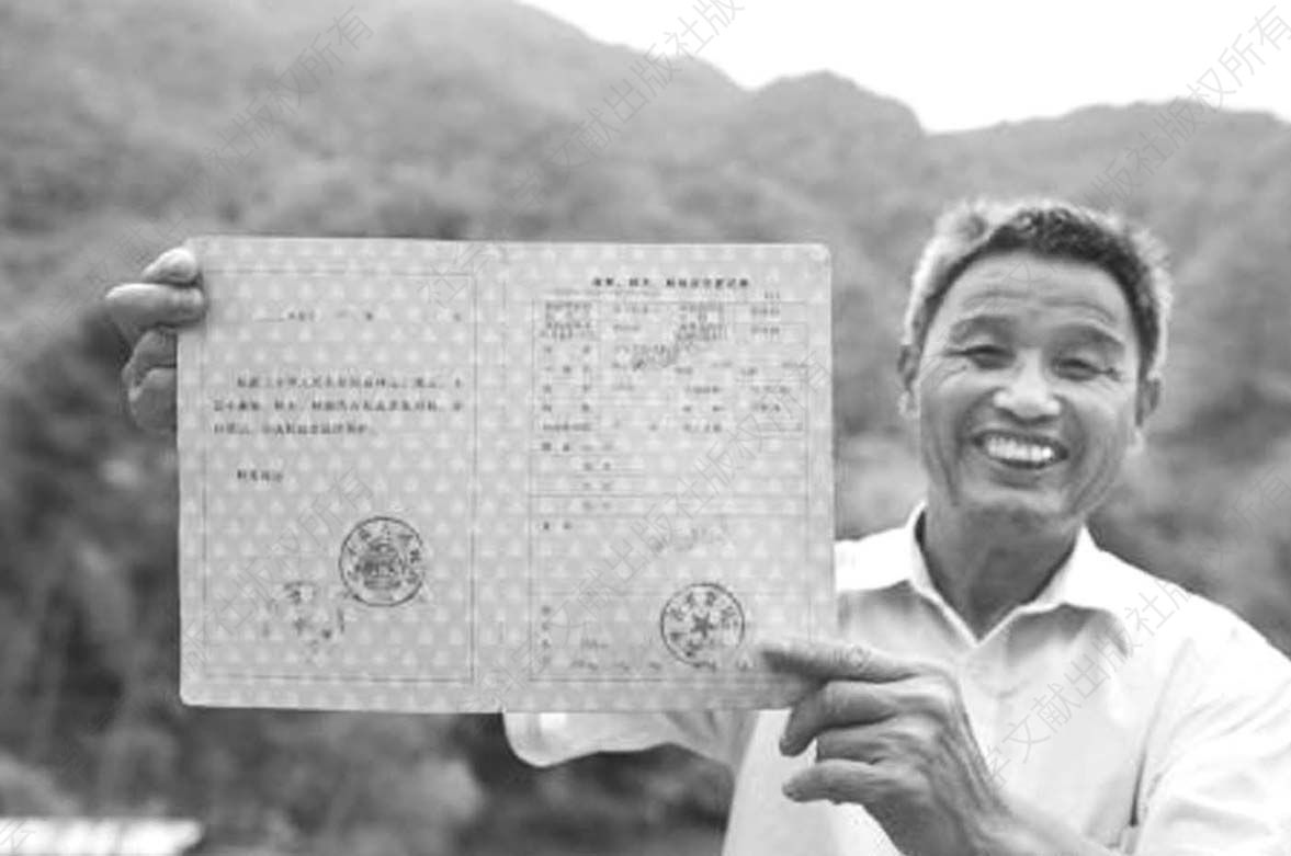 图1-2 捷文村村民李桂林展示个人持有的全国第一本新版林权证
