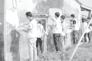 图10-6 信义志工协助社区修缮老屋（粉刷外墙）