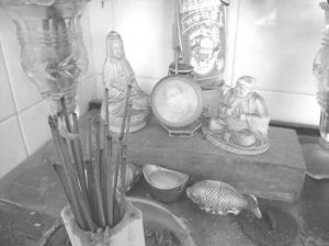 图7-7 老工人设在厨房的供桌：毛泽东像居中，左侧是观世音菩萨像，右侧是弥勒佛菩萨像